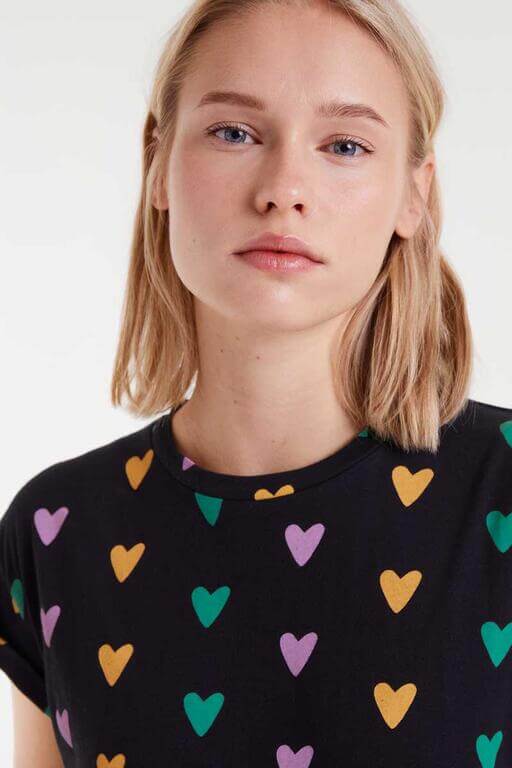 Detalle del estampado Cupido Lines en camiseta 100% algodón negra con corazones multicolor de Compañía Fantástica