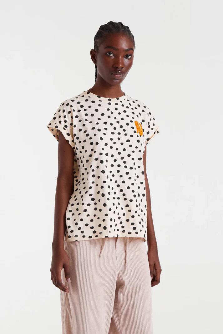 Camiseta Tano Dots de Compañía Fantástica Crudo y Negro de algodón 100% con diseño de lunares negros y detalle bordado naranja en el pecho.