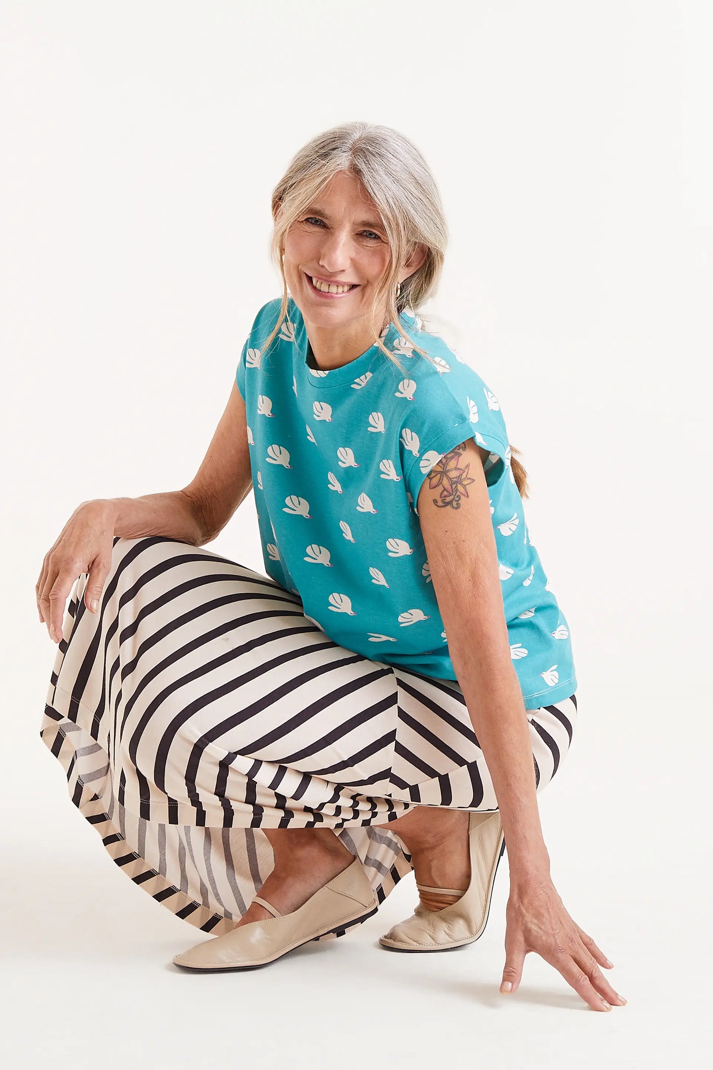 Camiseta Con Estampado Dove. Camiseta turquesa con estampado de palomas blancas, cuello redondo y mangas cortas.