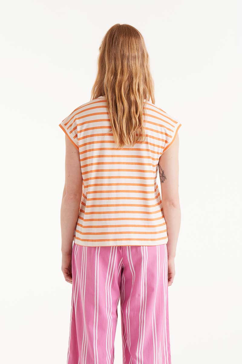 Camiseta-Estampado-Rayas-Naranjas-Compañía-Fantástica sin mangas con rayas naranja pastel sobre fondo blanco y bordado de flor rosa en el pecho. Ideal para looks veraniegos casuales en la categoría de camisetas para mujer.