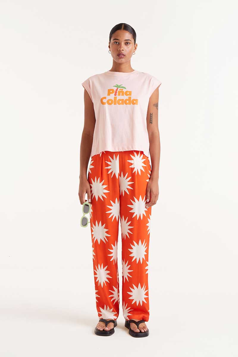 Pantalon-Largo-Big-Sun-Naranja-Compañía-Fantástica con estampado de soles blancos, tejido fluido y corte recto, ideal para primavera-verano.
