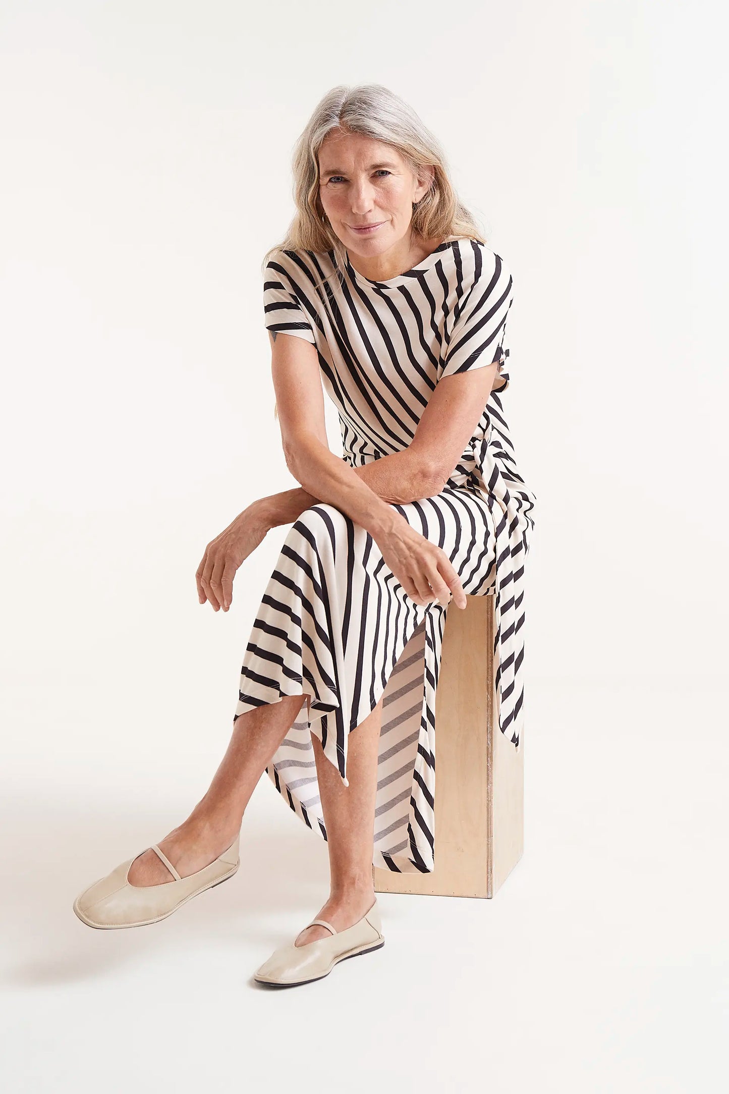 Vestido Midi Estampado Rayas Piano. Modelo con vestido midi de rayas blancas y negras con nudo lateral.