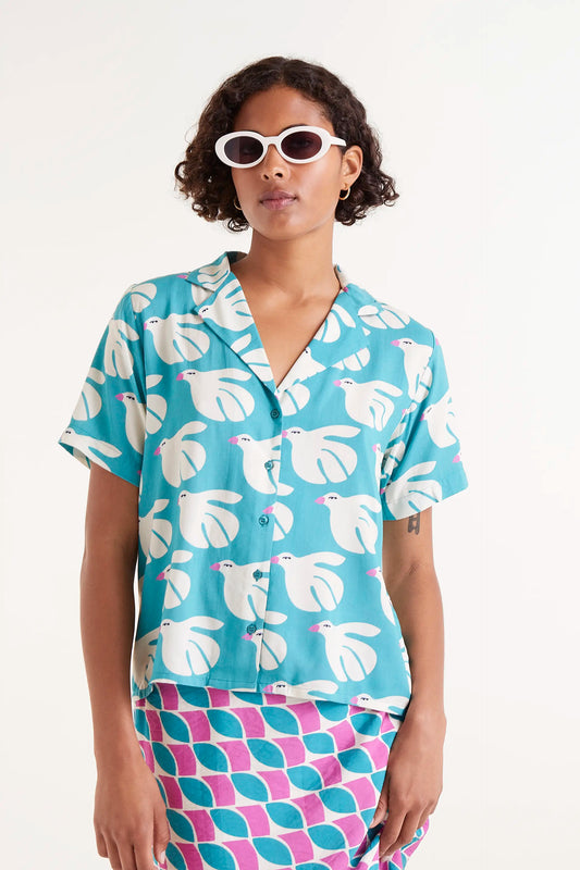 Camisa Rayon Estampado Dove. Camisa de manga corta con estampado de palomas blancas sobre fondo azul turquesa.