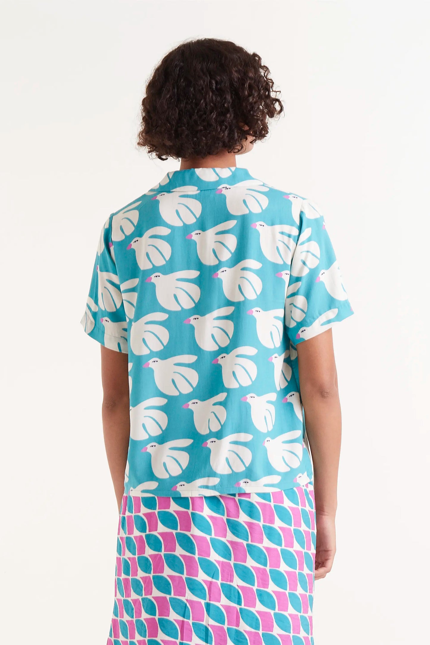 Camisa Rayon Estampado Dove. Camisa de manga corta con estampado de palomas blancas sobre fondo azul turquesa.