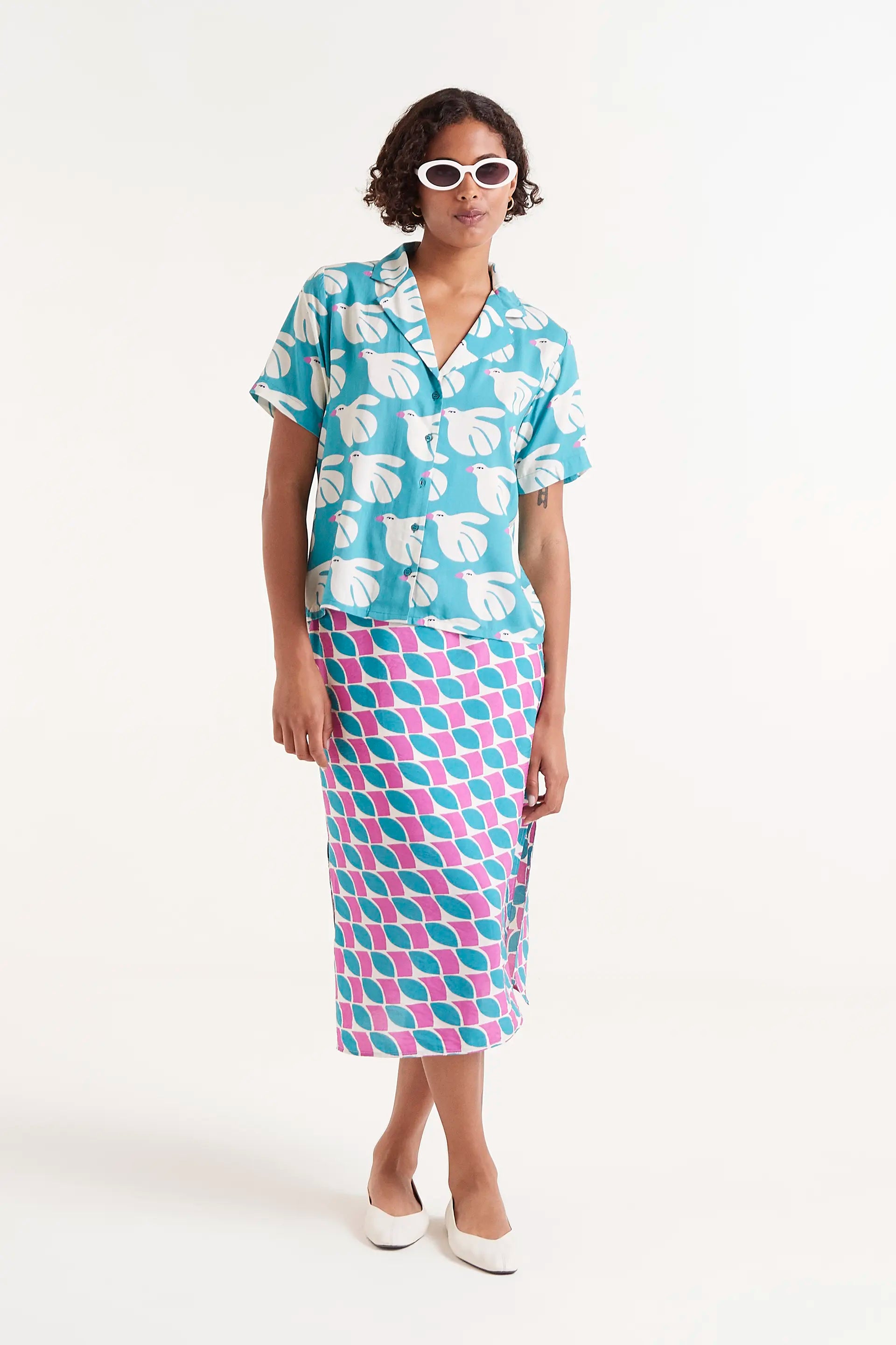 Camisa Rayon Estampado Dove. Camisa de manga corta con estampado de palomas blancas sobre fondo azul turquesa.