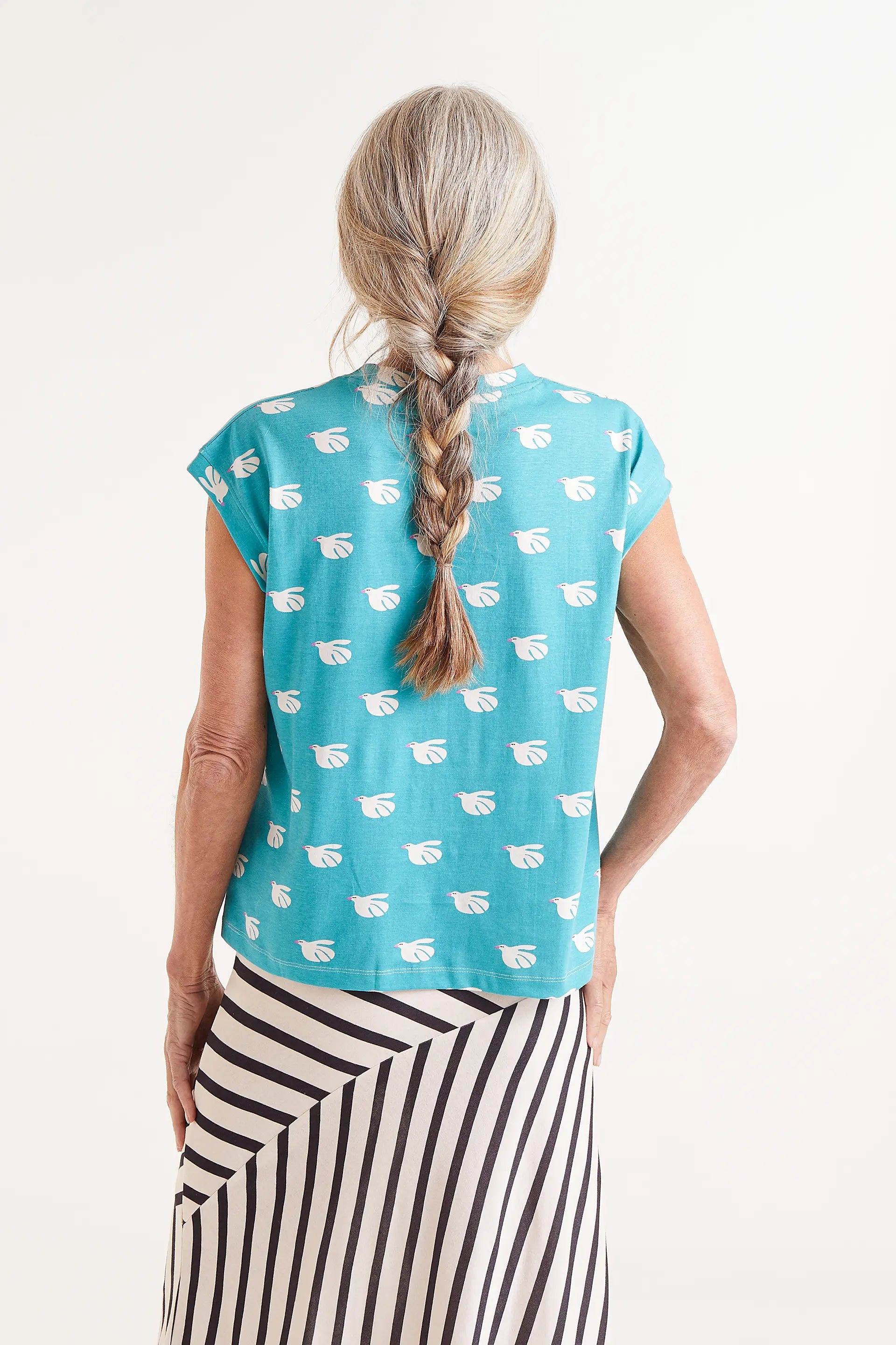 Camiseta Con Estampado Dove. Camiseta turquesa con estampado de palomas blancas, cuello redondo y mangas cortas.
