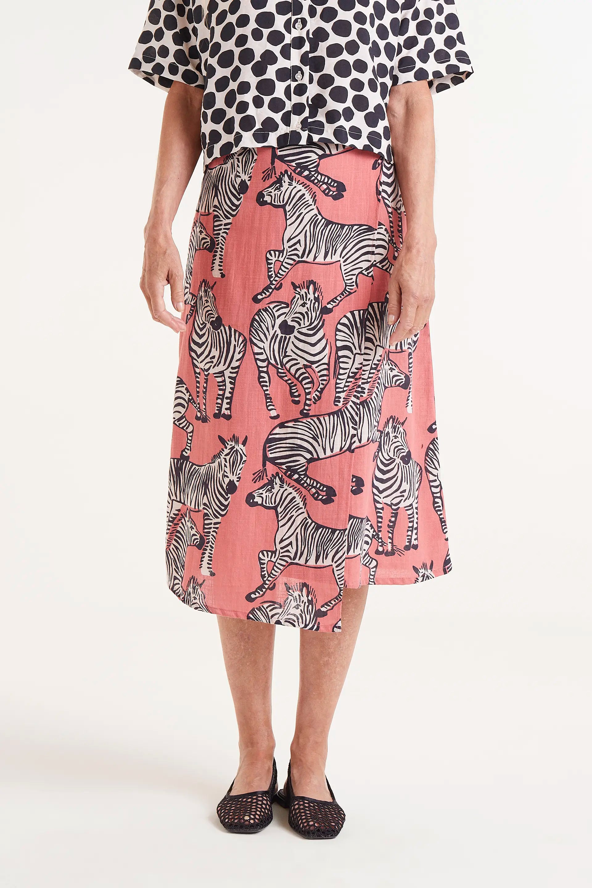 Falda Midi Estampado Cebras. Falda midi con estampado de cebras sobre fondo coral, cintura elÃ¡stica y caÃ­da fluida.