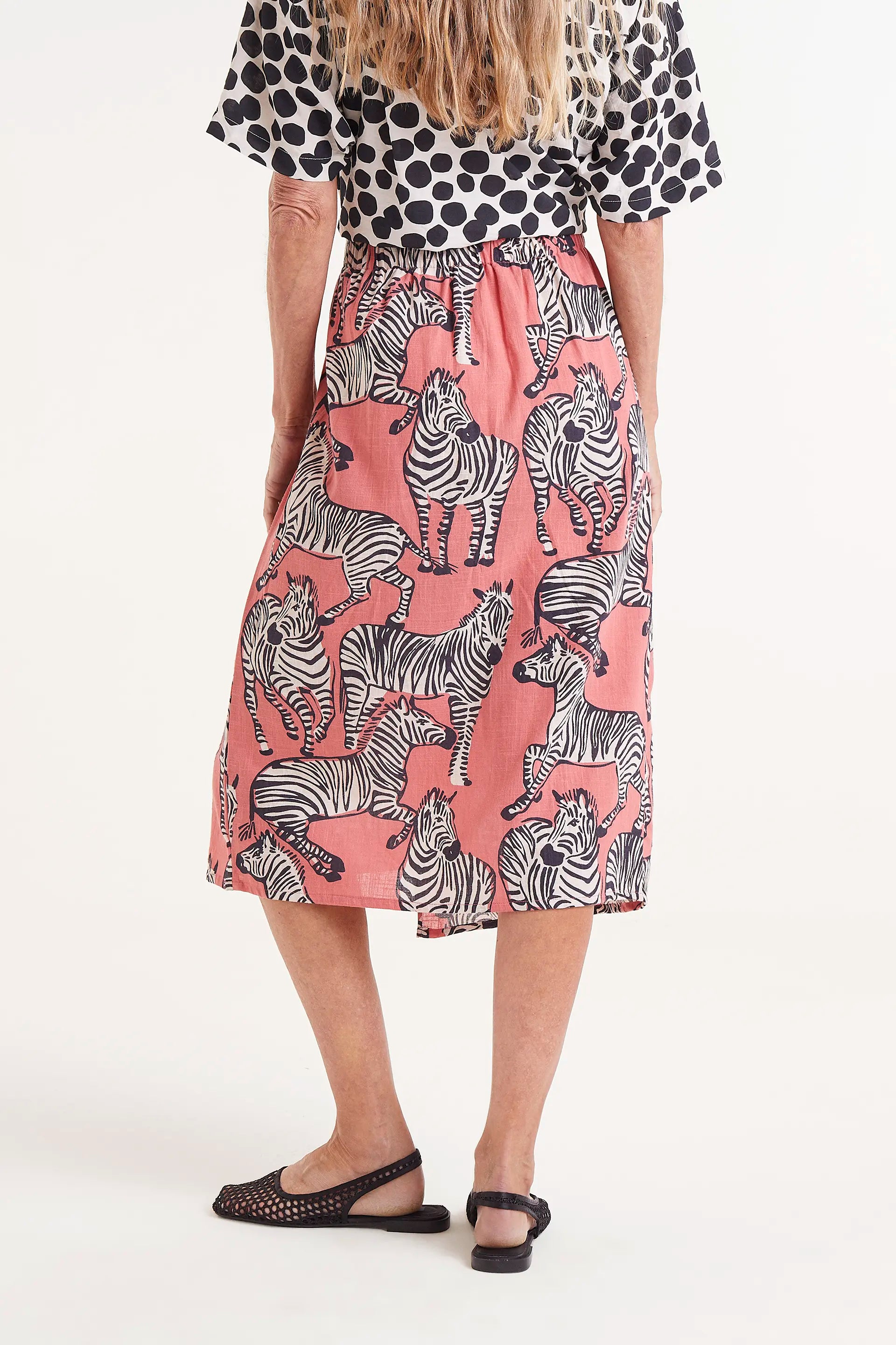 Falda Midi Estampado Cebras. Falda midi con estampado de cebras sobre fondo coral, cintura elÃ¡stica y caÃ­da fluida.