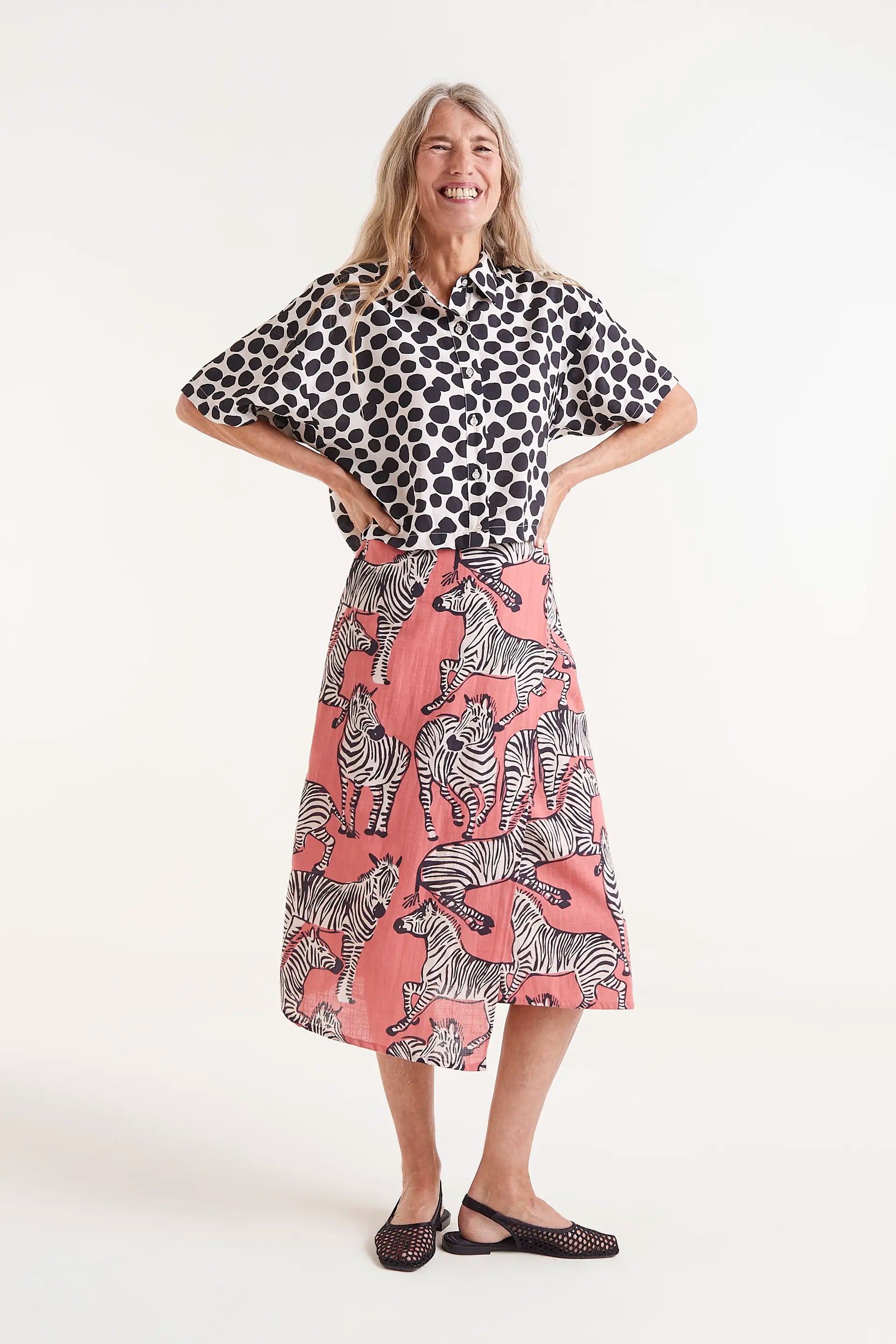 Falda Midi Estampado Cebras. Falda midi con estampado de cebras sobre fondo coral, cintura elÃ¡stica y caÃ­da fluida.