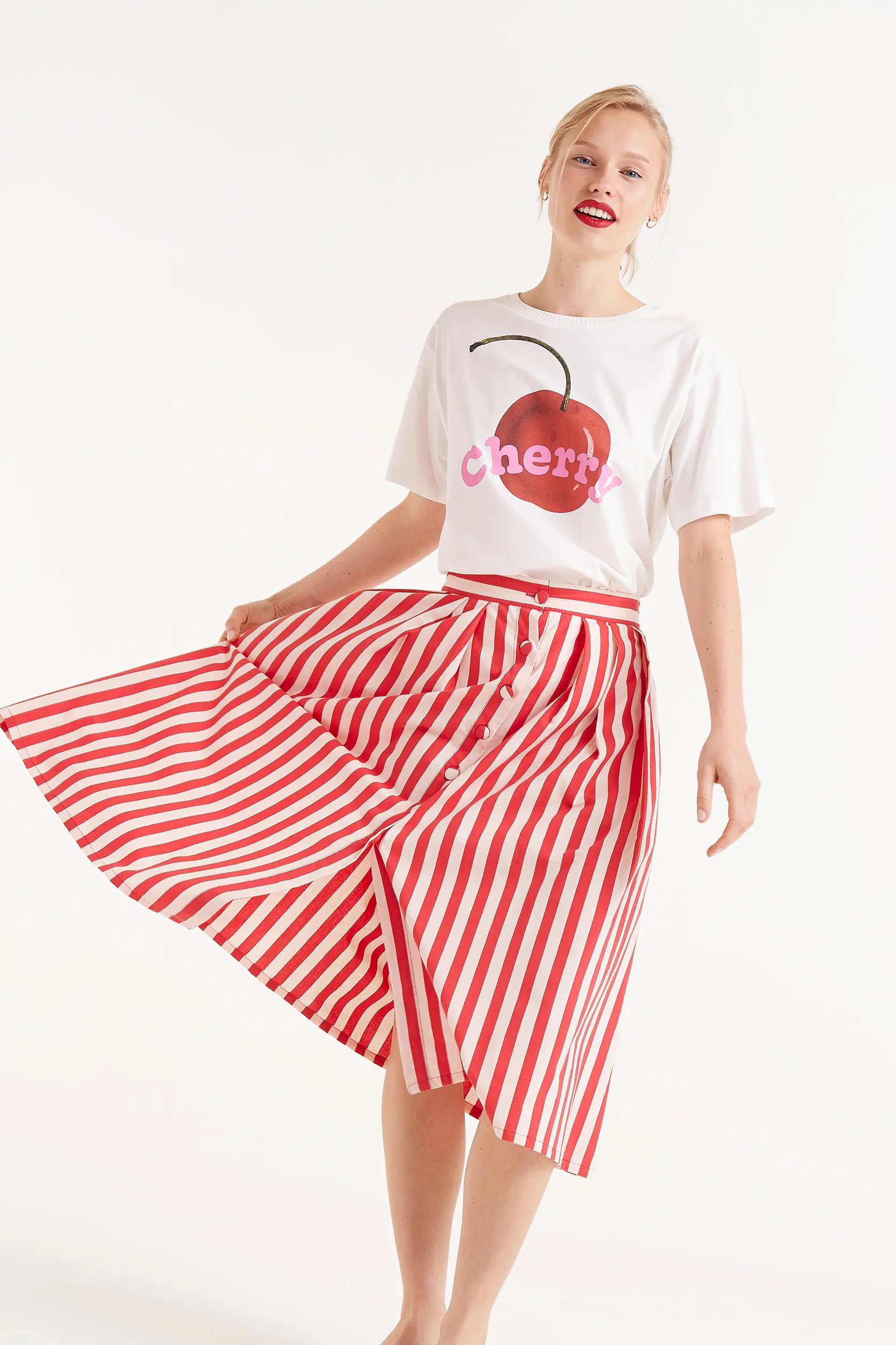 Falda Midi Estampado Rayas Rojas. Falda midi con rayas rojas y blancas, cierre frontal con botones y corte amplio.