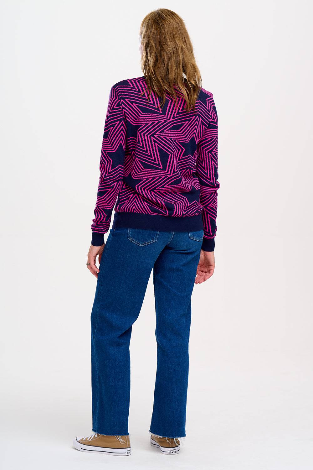 Vista trasera del Jersey Rosie Sugar Hill Brighton con estampado de estrellas en tonos rosa y azul, combinado con jeans.