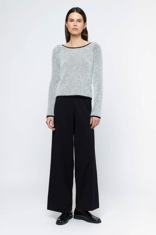 Jersey de textura blanco y negro Wild Pony combinado con pantalón negro, estilo casual y moderno para mujer.
