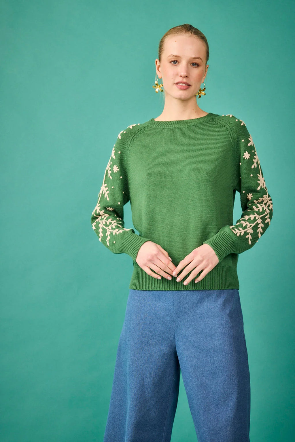 Jersey verde con bordado floral en las mangas