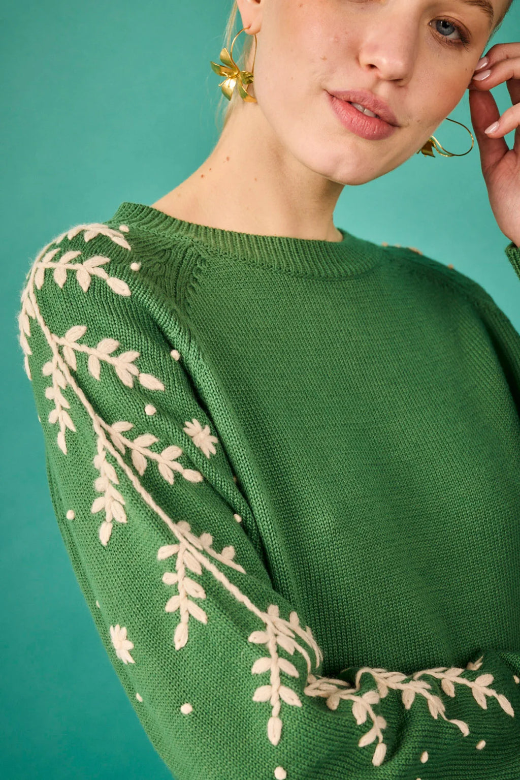 Jersey verde con bordado floral en las mangas