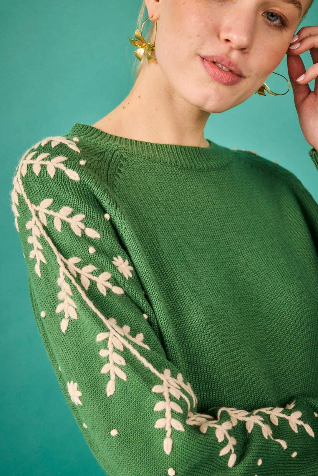 Jersey verde con bordado floral en las mangas