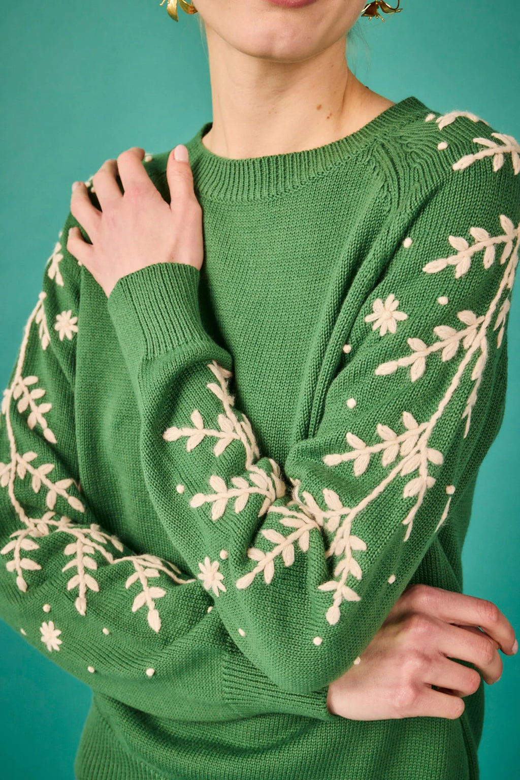Jersey verde con bordado floral en las mangas