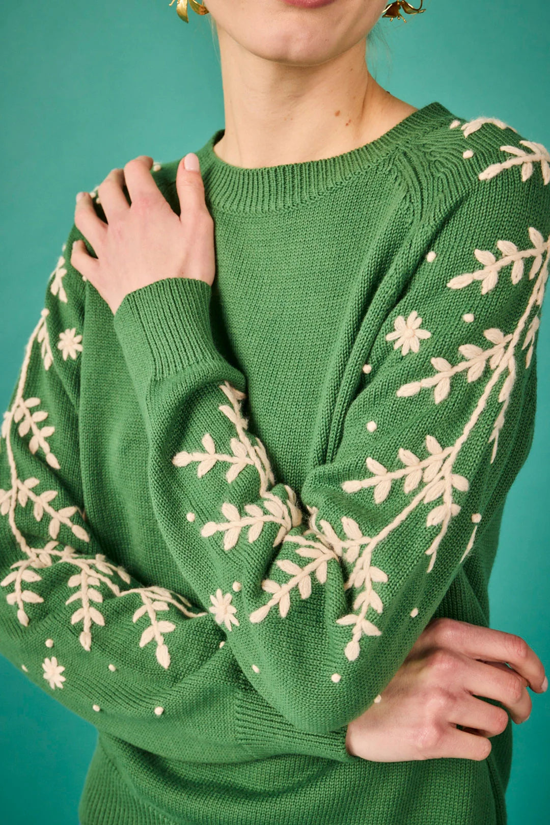Jersey verde con bordado floral en las mangas