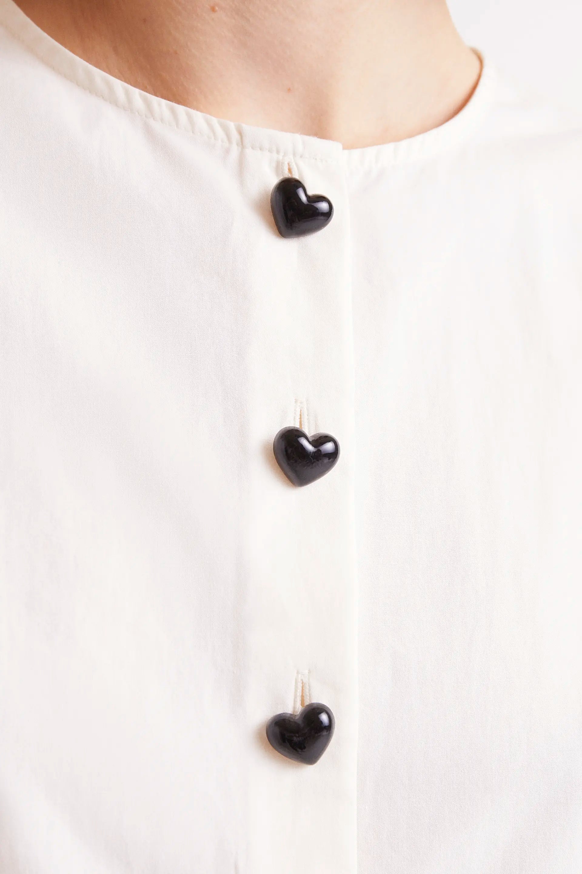 Top Sin Mangas Con Botones Blanco. Top blanco sin mangas con botones negros en la parte frontal.