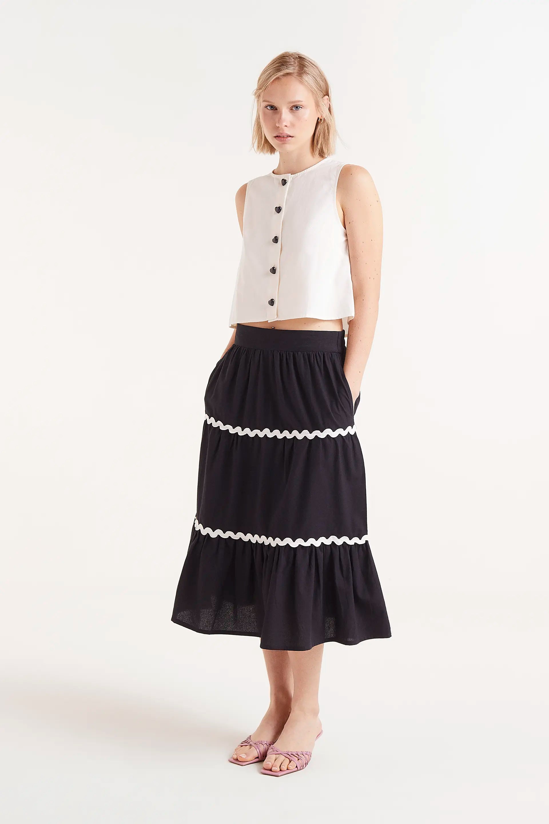 Top Sin Mangas Con Botones Blanco. Top blanco sin mangas con botones negros en la parte frontal.