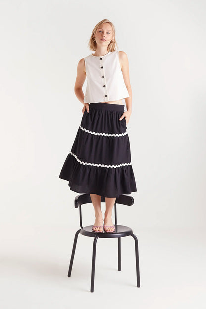 Top Sin Mangas Con Botones Blanco. Top blanco sin mangas con botones negros en la parte frontal.