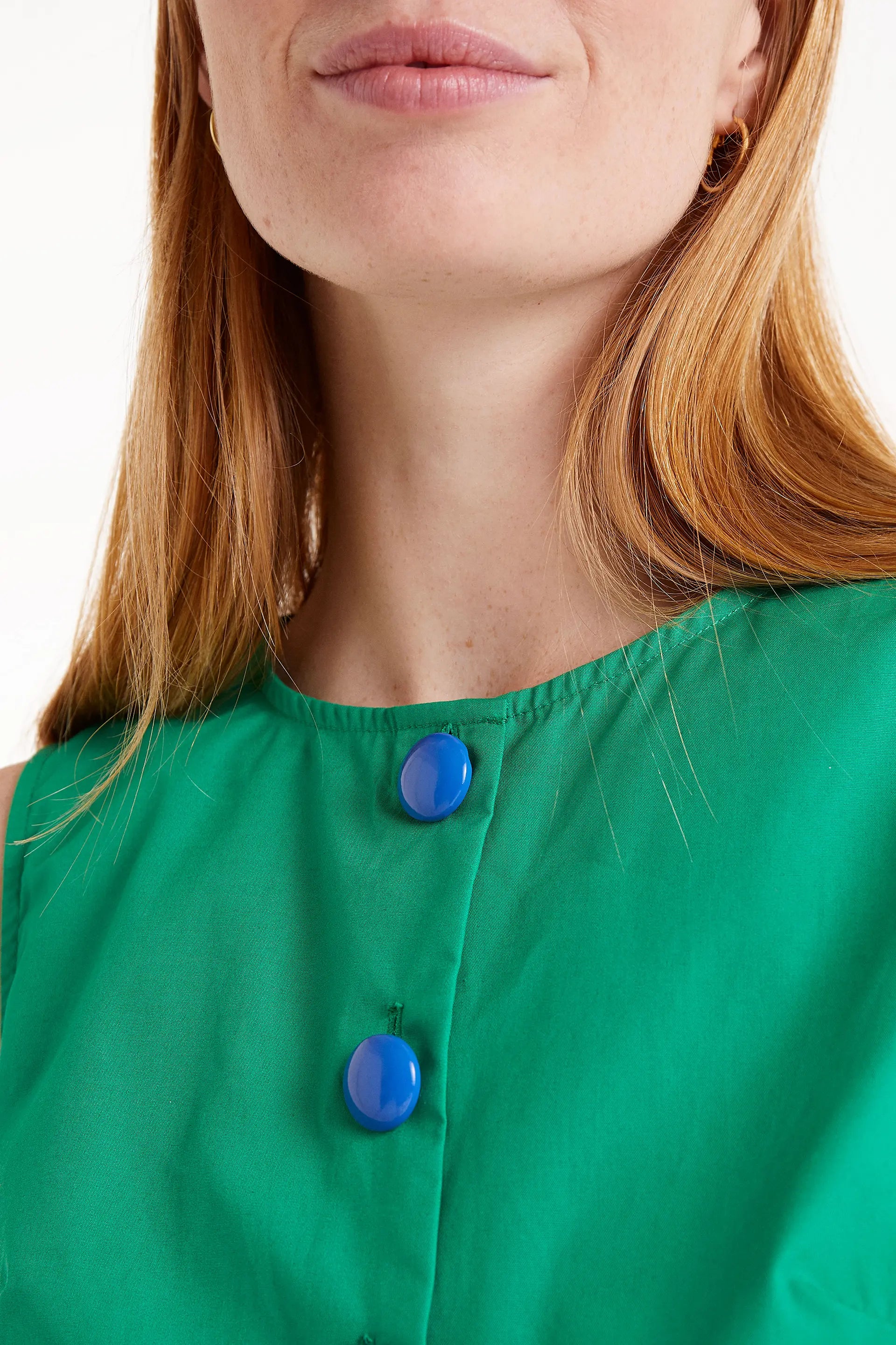 Top Sin Mangas Con Botones Verde. Top verde sin mangas con botones azules al frente.