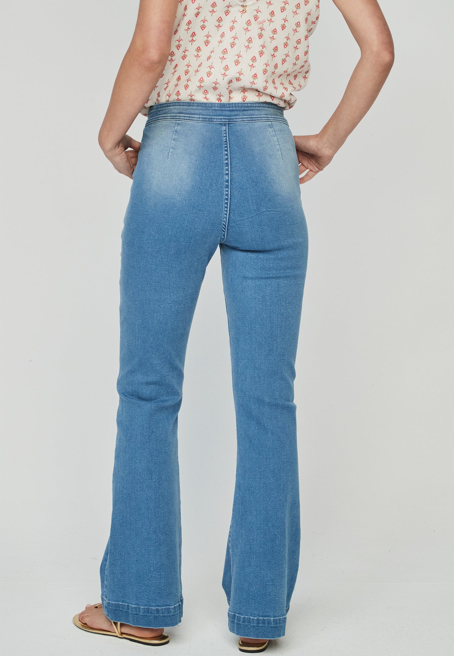Jeans Kurai Unique con botonadura lateral en madera reciclada y corte bootcut. Diseño retro ideal para un look sofisticado y moderno.