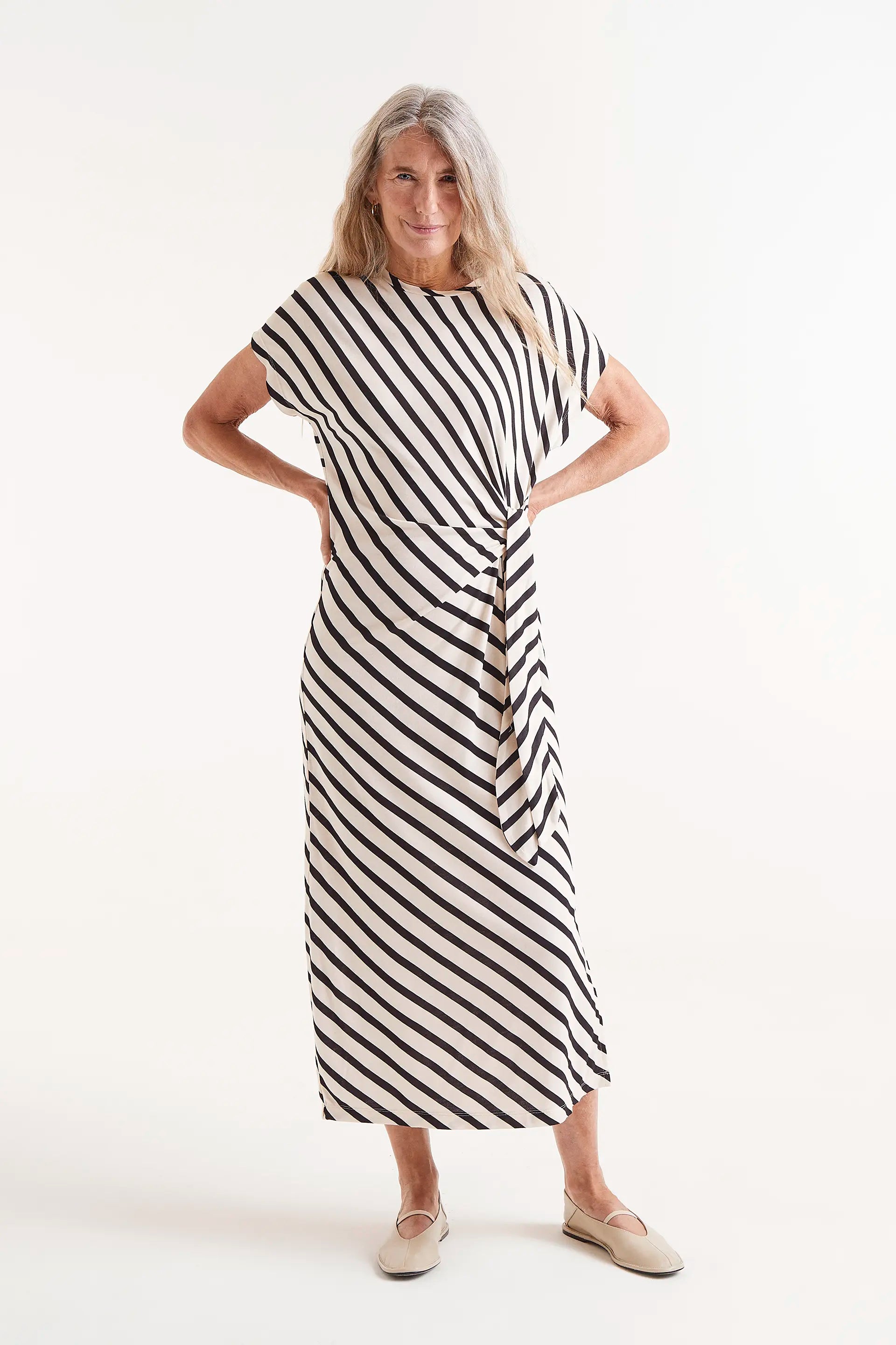 Vestido Midi Estampado Rayas Piano. Modelo con vestido midi de rayas blancas y negras con nudo lateral.