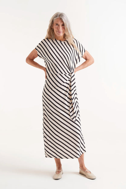 Vestido Midi Estampado Rayas Piano. Modelo con vestido midi de rayas blancas y negras con nudo lateral.