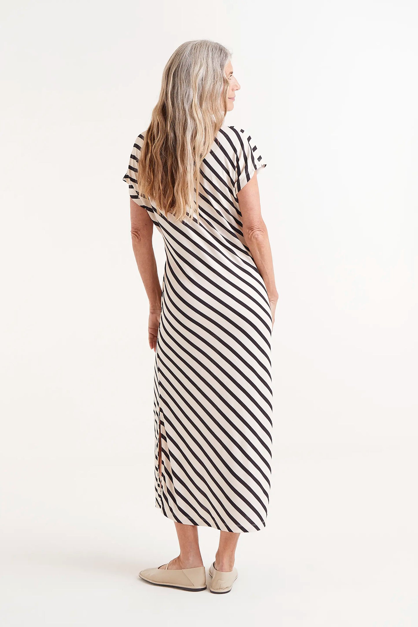 Vestido Midi Estampado Rayas Piano. Modelo con vestido midi de rayas blancas y negras con nudo lateral.